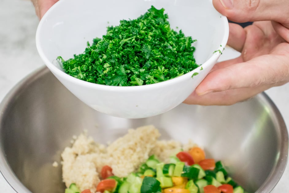 adding chopped parsley to tabbouleh