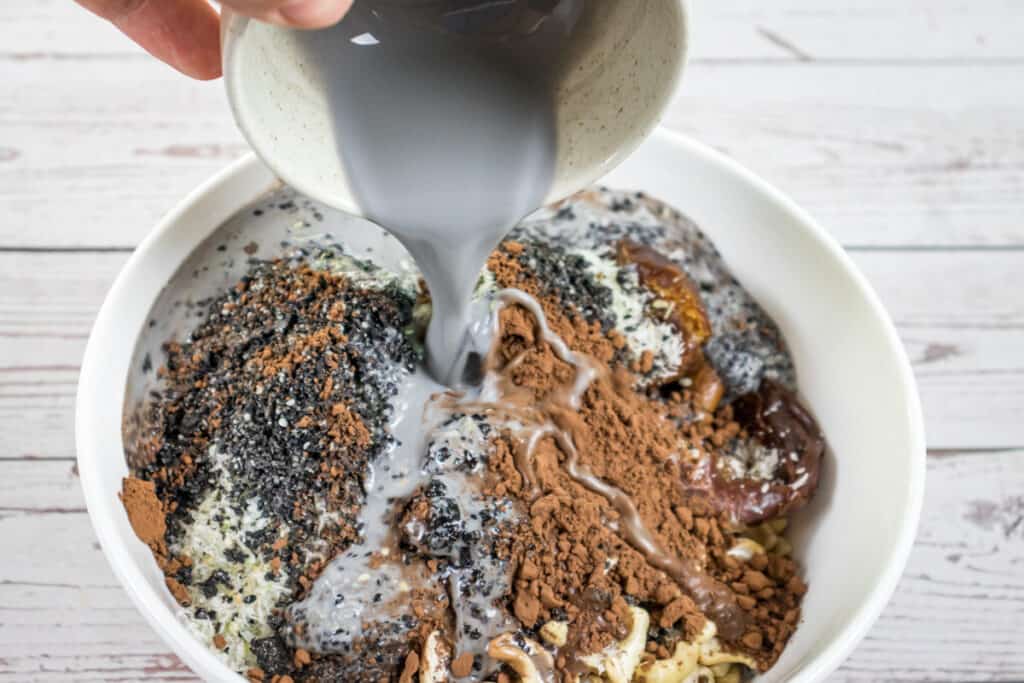 adding-the-black-sesame-milk-to-thechocolate-bliss-ball-mix