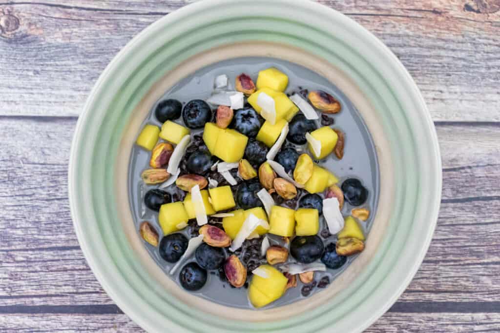 black-rice-pudding-with-mango-blueberries-and-pistachio-served-in-a-bowl