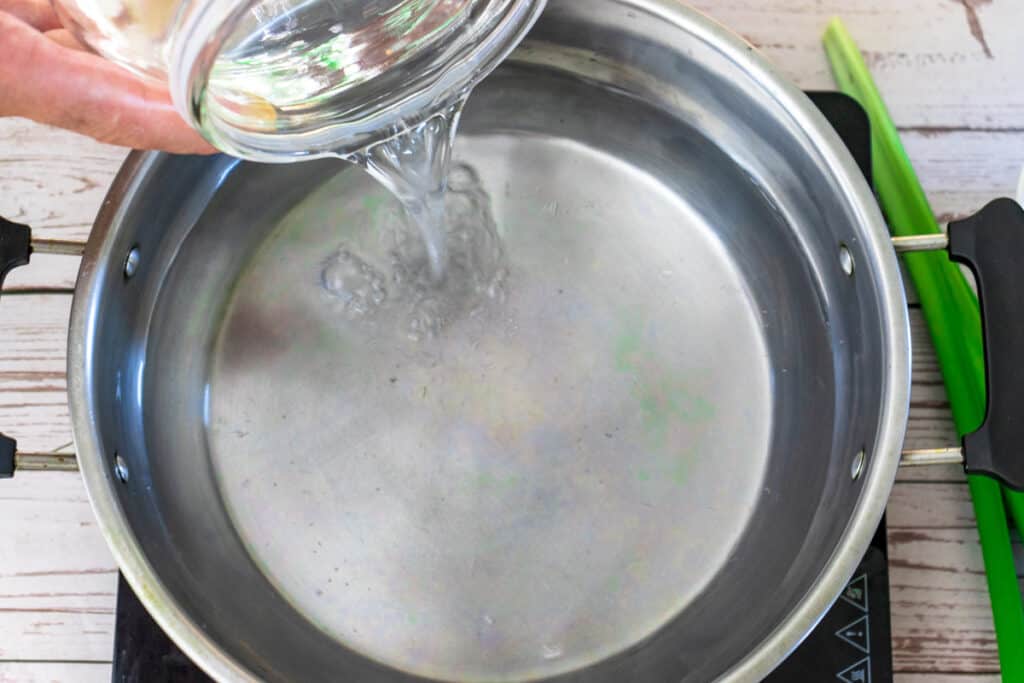 pouring-water-into-saucepan-to-make-malva-juice