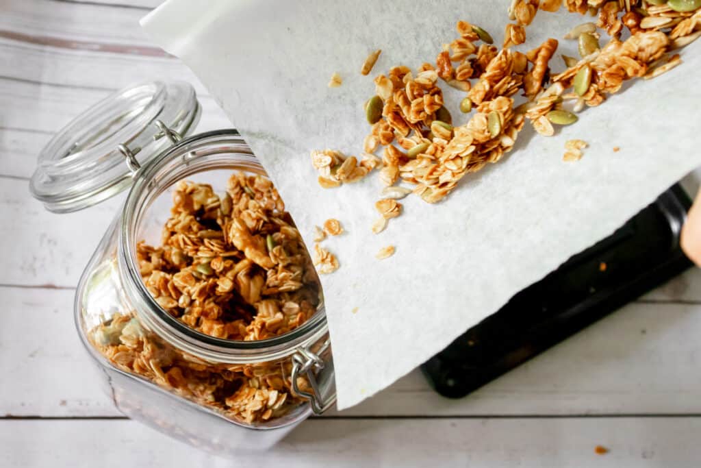 pouring-granola-into-a-jar-with-parchment-paper