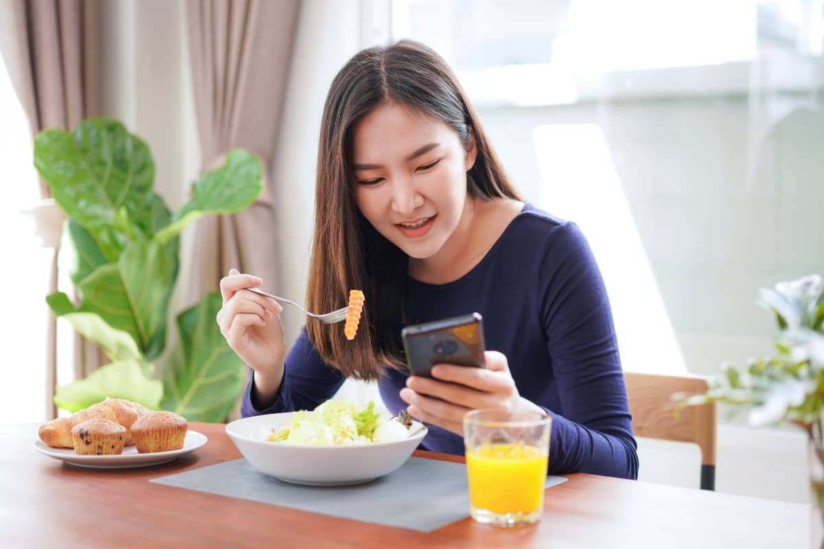 woman-looking-on-the-phone-while-eating