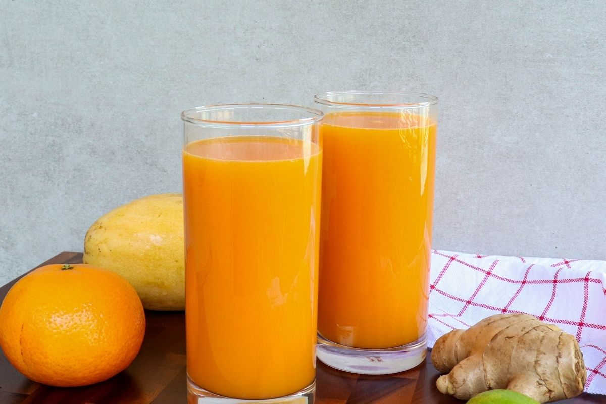 Cold pressed Golden Glow Juice served in glasses with fresh tropical ingredients