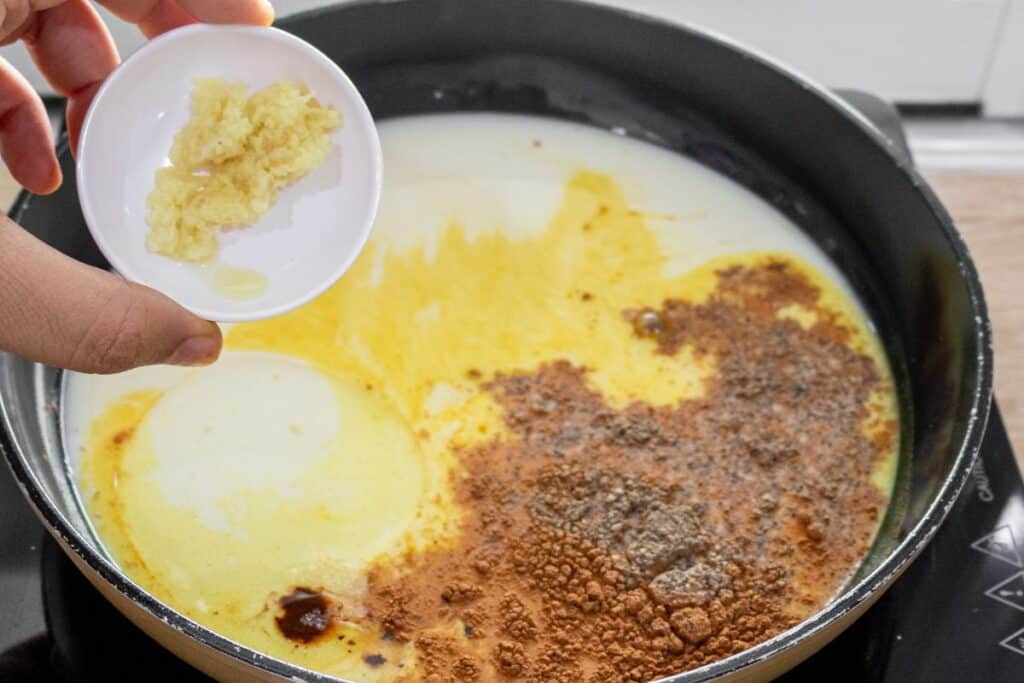 adding-grated-ginger-to-golden-turmeric-milk