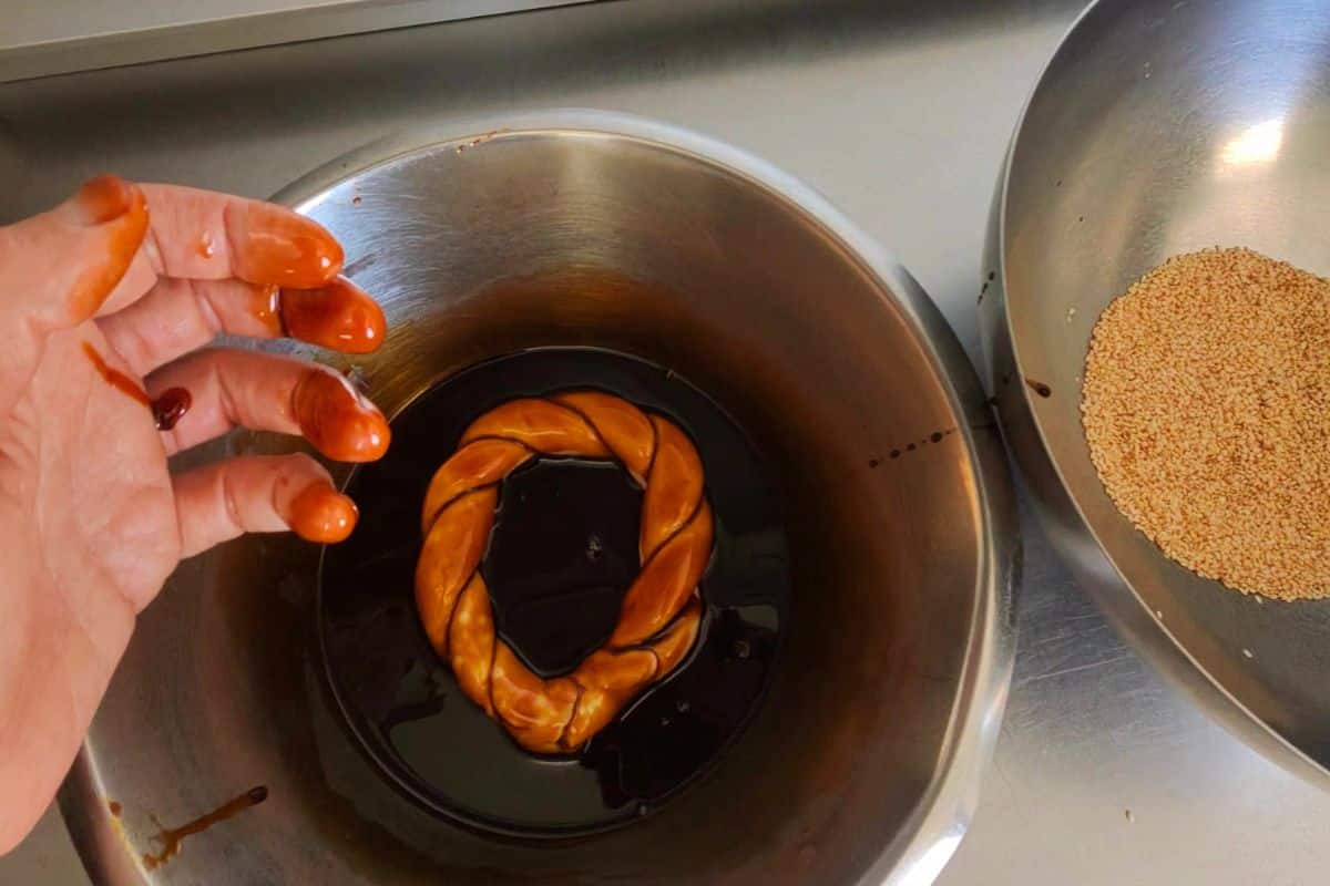 dipping simit dough in pekmes grape molasses