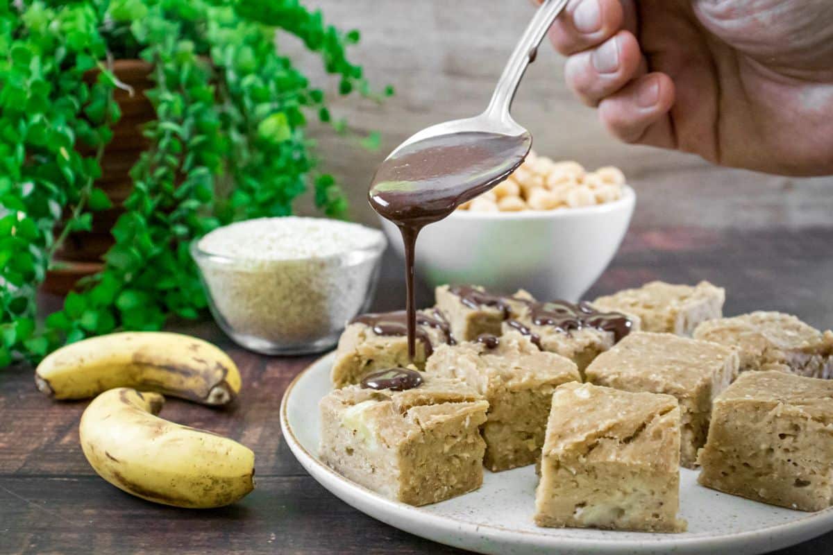Chickpea blondies cut into squares with a drizzle of melted dark chocolate on top