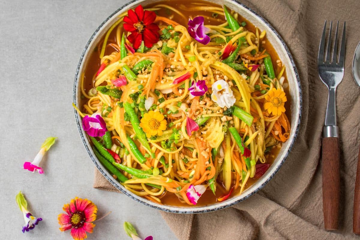 Finished green mango salad served fresh in a white bowl