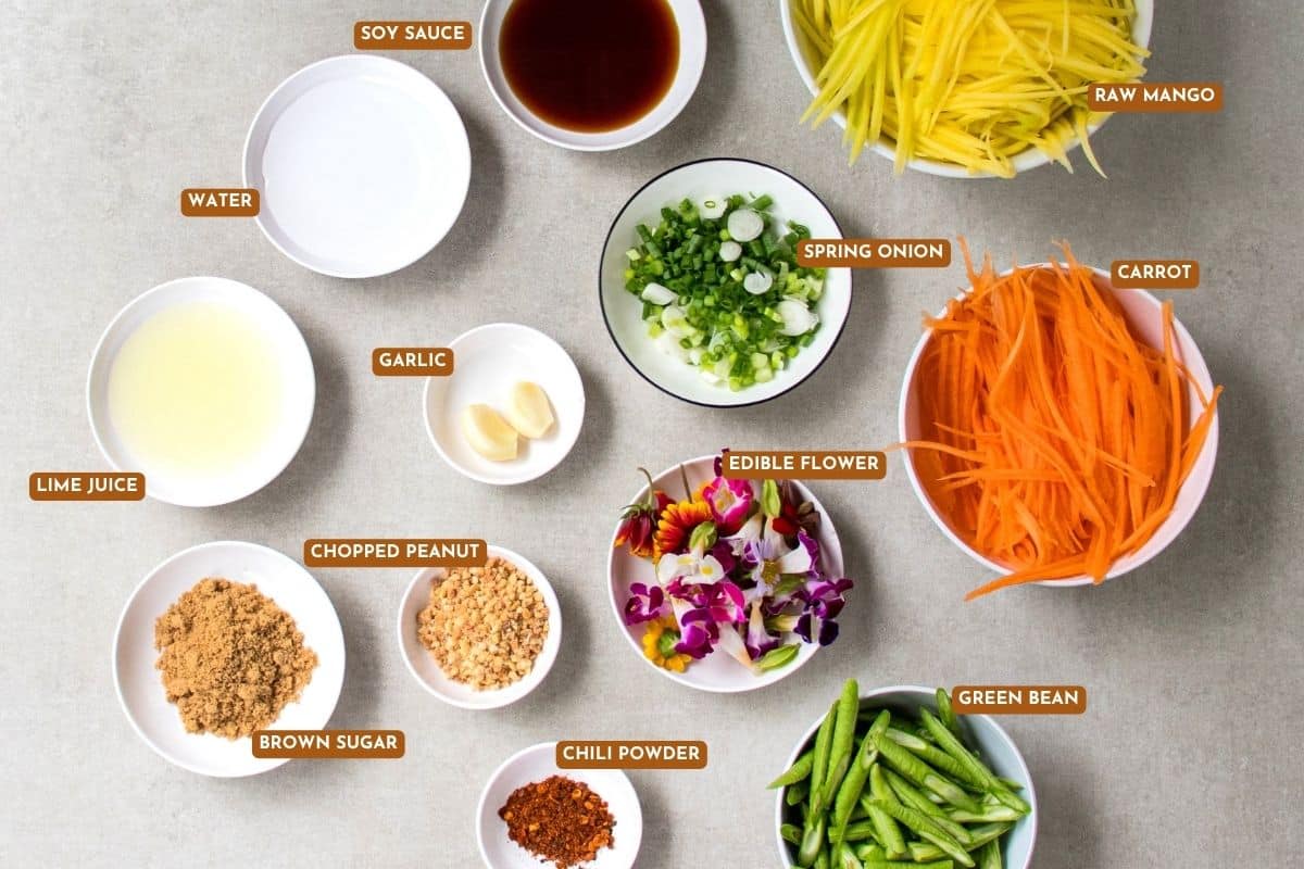Plant-based green mango salad ingredients with lime, garlic, chili, and peanuts