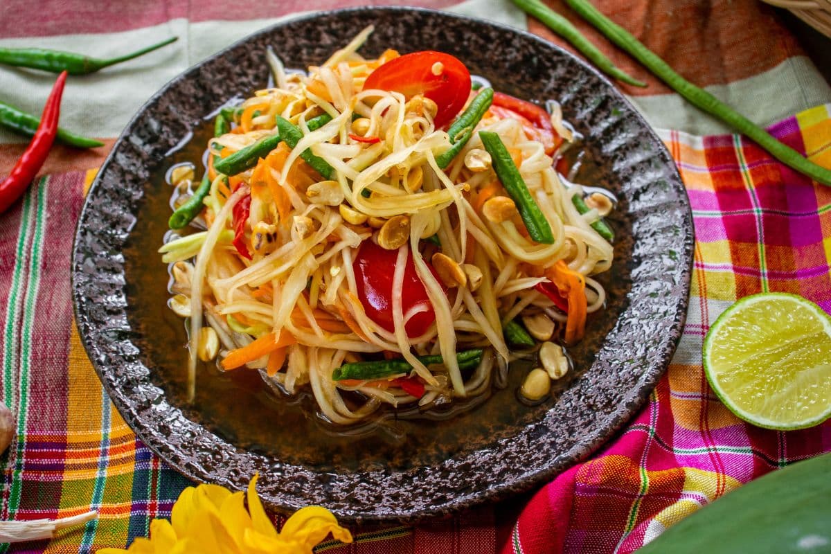 Vegan green papaya salad with cherry tomatoes, green beans and roasted peanuts.