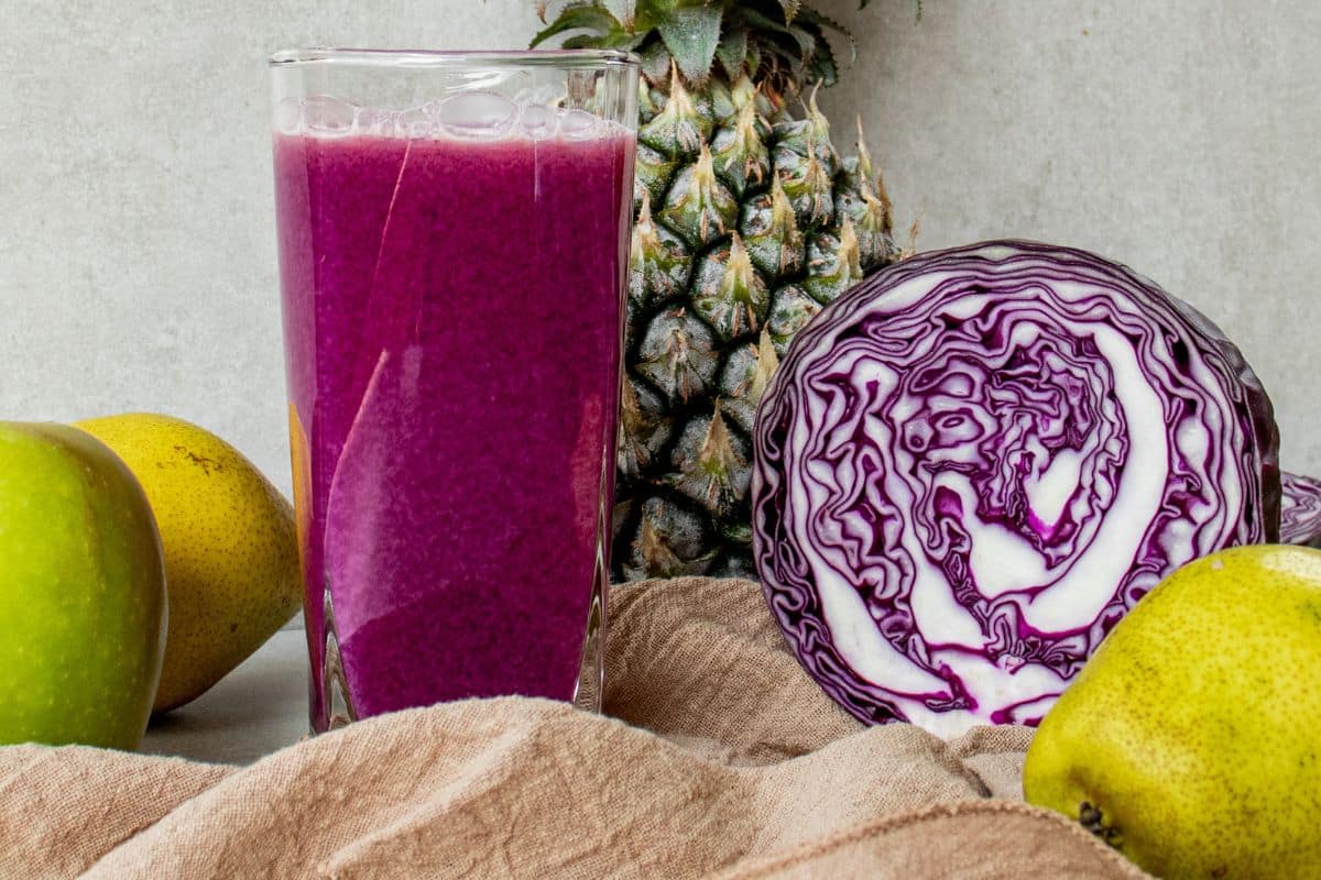 Homemade purple cabbage juice with pineapple, cucumber, pear, apple and ginger