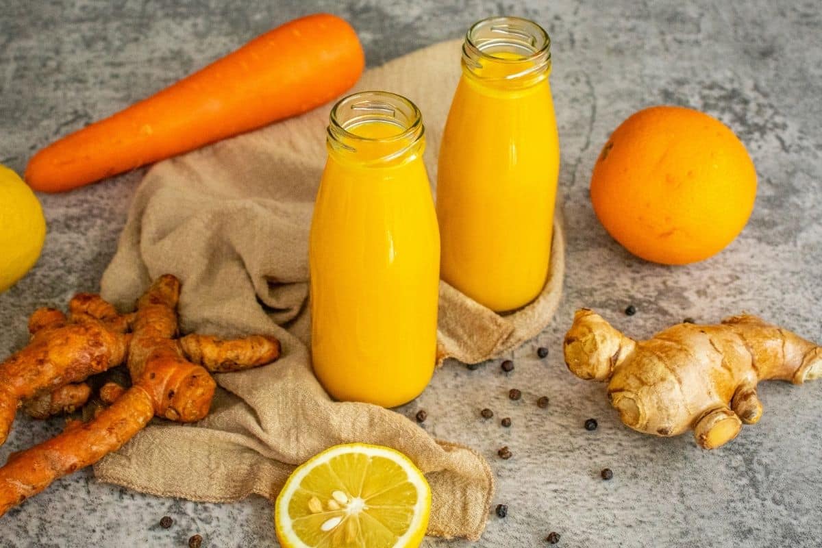 Golden homemade turmeric shots prepared with fresh wholefood ingredients and bottled for the week.