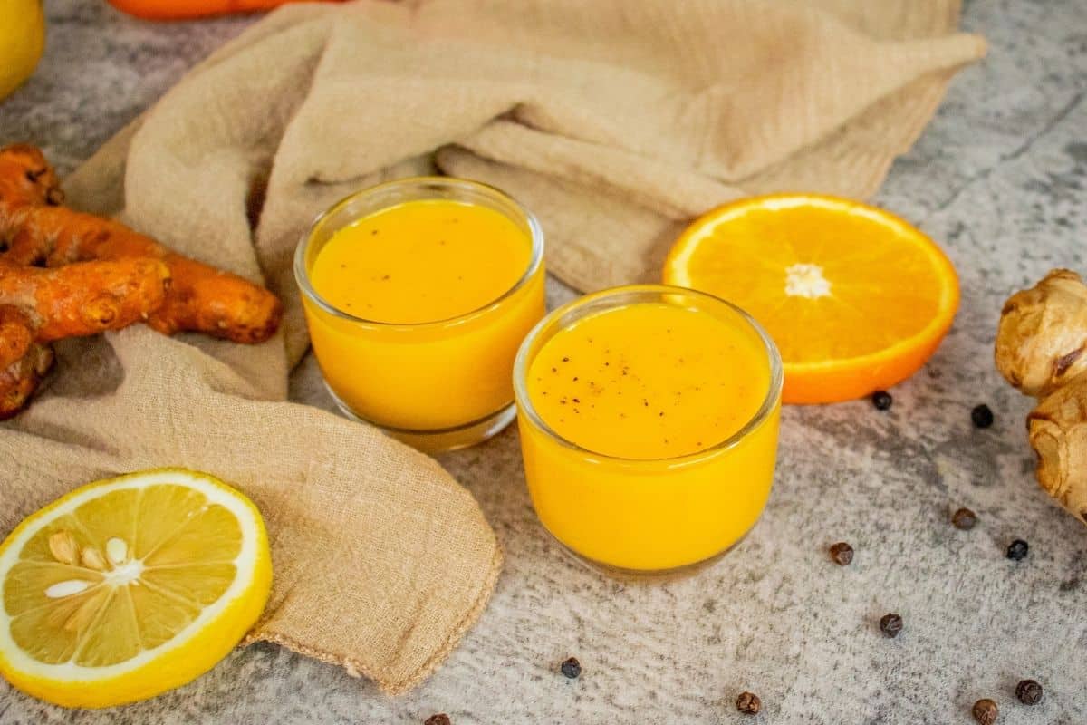 pouring homemade turmeric shots into small glasses