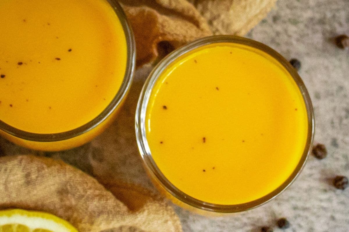 Homemade turmeric wellness shots made with fresh turmeric, ginger, orange, lemon, carrot and black pepper.