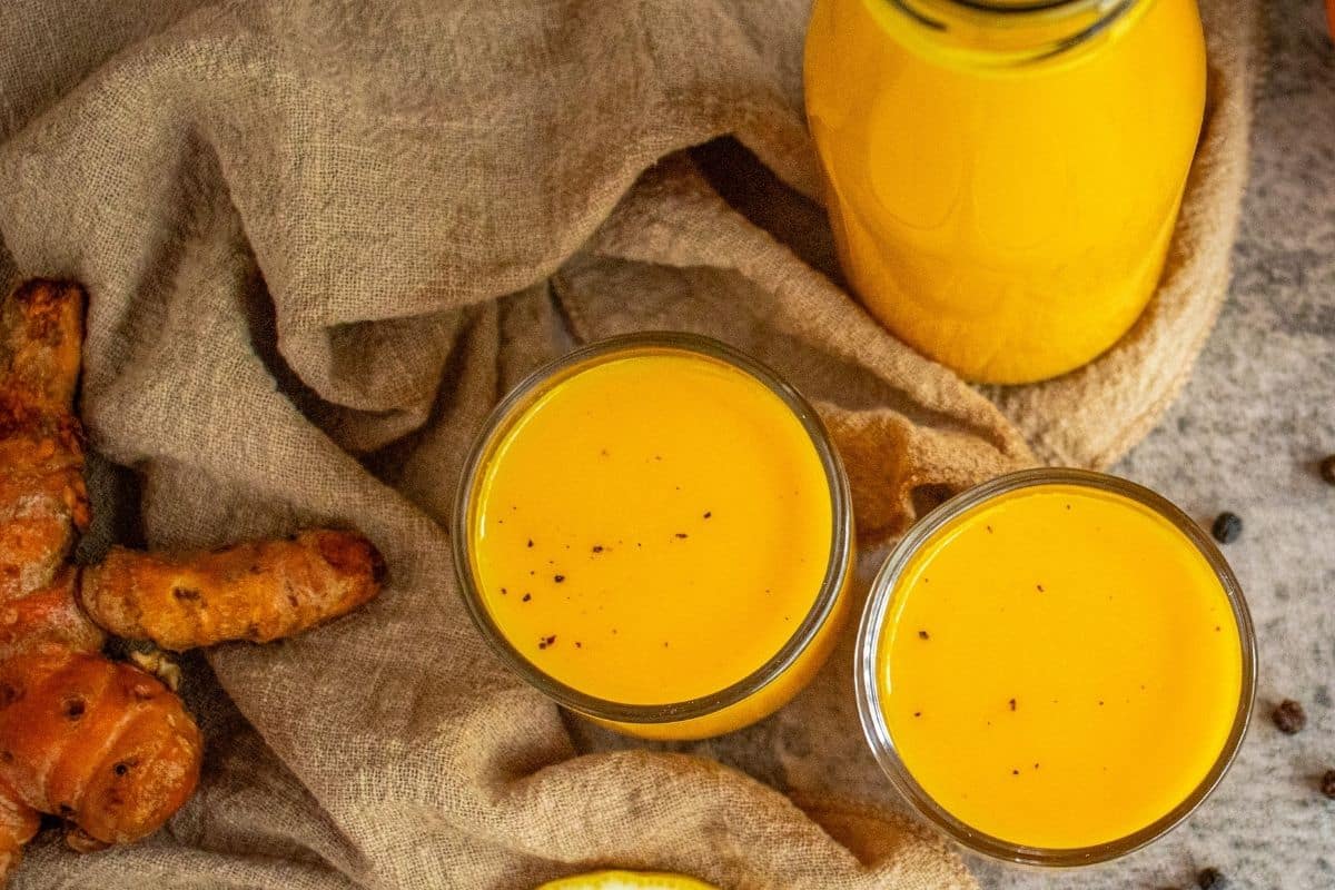 Golden homemade turmeric shots prepared with fresh wholefood ingredients and bottled for the week.