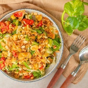 Burmese tea leaf salad (Lahpet Thoke) with fermented tea leaves, cabbage, cos lettuce, tomatoes, peanuts and crispy fava beans.