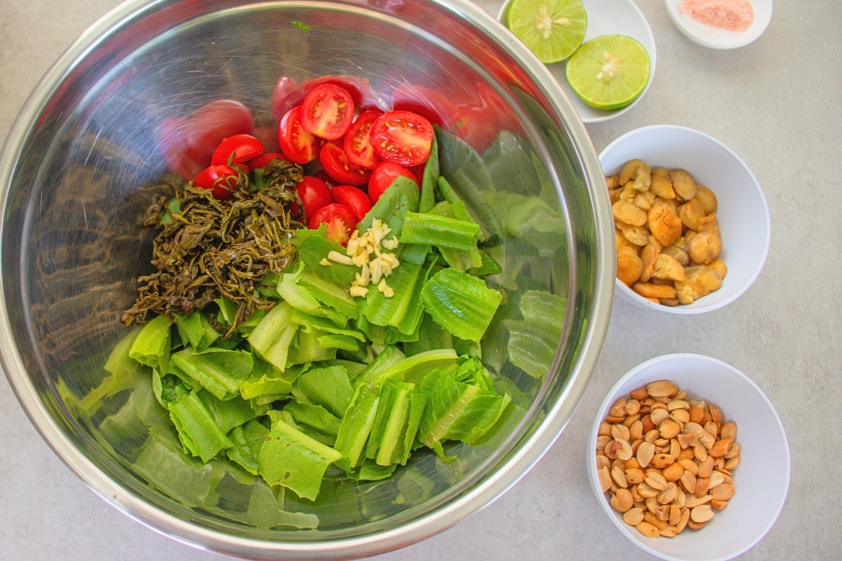 Fermented tea leaves and chopped garlic added to Burmese Tea Leaf Salad