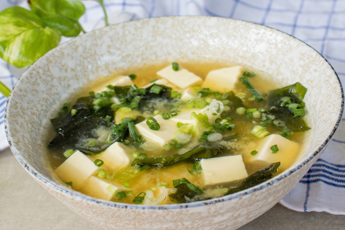 Japanese miso soup with tofu, wakame and spring onions in a ceramic bowl