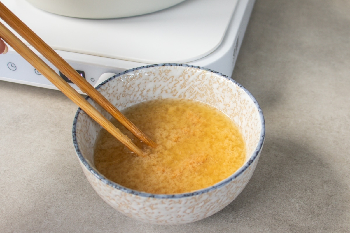 Gently stir - Use chopsticks or a small whisk to gently mix the miso into the warm broth.